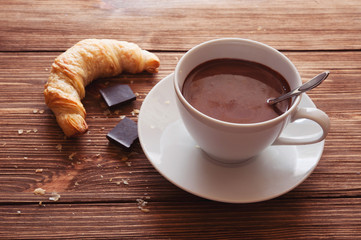 Hot chocolate in a white cup on a wooden table
