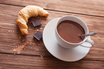 Hot chocolate in a white cup on a wooden table