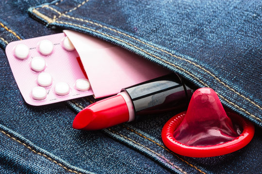 Pills condom and lipstick in denim pocket.