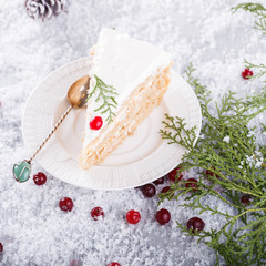 Cake with white cream,garnished with sprigs of spruce ,pine cones,cranberries.