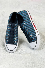 blue tennis shoes on gray background