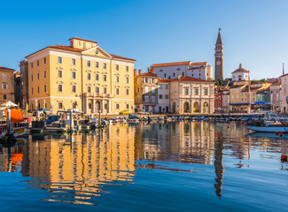Fototapeta na wymiar Venetian Port and The Main Square Tartini of Piran City Reflected on Water in Slovenia.