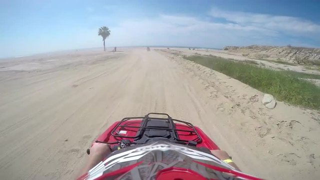 First person POV of a four wheeler driving on trails at the coast