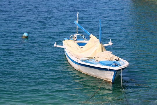 Small wooden boat in clear blue sea. In town Vela Luka, on the Korcula island, Croatia.