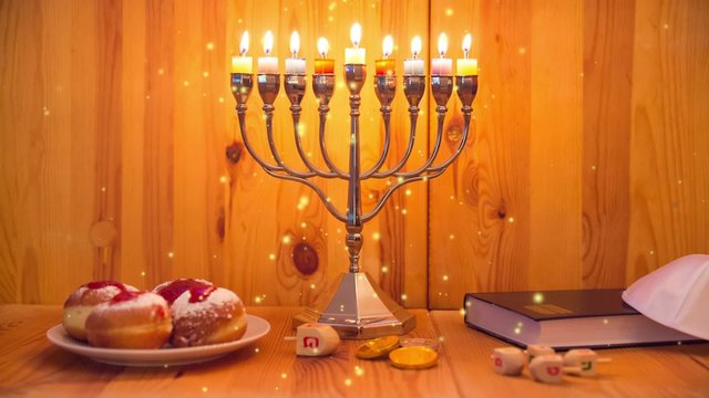 Jewish Holiday Hanukkah with Menorah (traditional Candelabra), donuts ( sufganiyot ) and wooden dreidels with glitter overlay