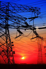 The silhouette of the evening electricity transmission pylon
