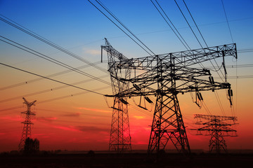 The silhouette of the evening electricity transmission pylon