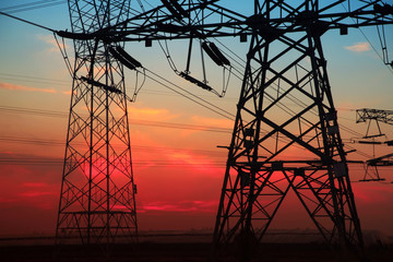 The silhouette of the evening electricity transmission pylon