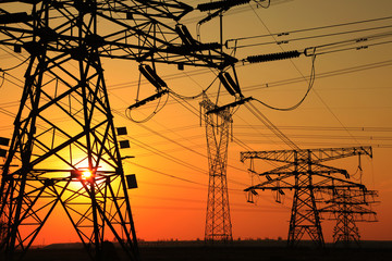 The silhouette of the evening electricity transmission pylon