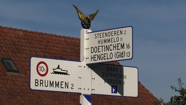 Rural village + zoom in nostalgic direction sign in Dutch countryside. BRONKHORST, THE NETHERLANDS  