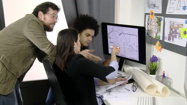 Architects working on map of house in office