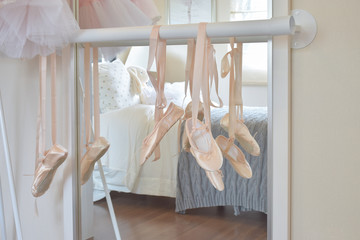 ballet shoes hang on bar in bedroom