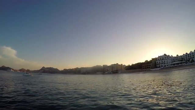 View of hills and a city on the coast, from a boat on the ocean