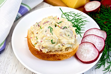 Appetizer of radish and cheese on bun in plate with napkin
