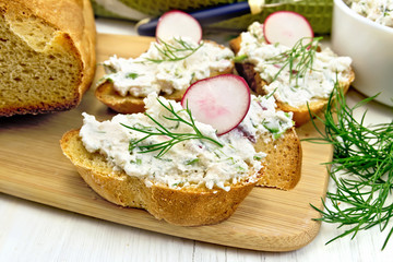 Bread with pate of curd and radish on board