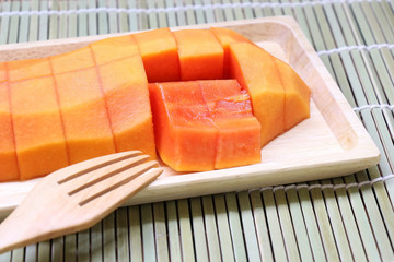 Delicious ripe papaya in a wooden tray.