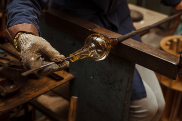 Glass Artist in her workshop making glassware