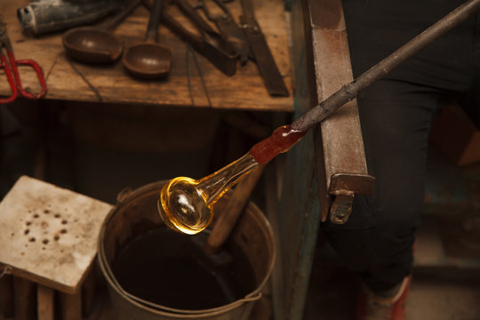 Glass Artist in her workshop making glassware