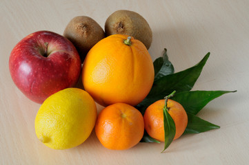 winter fruit
frutta invernale, un'arancia, un limone, una mela rossa, due kiwi e due clementine con alcune foglie verdi, luce solare.