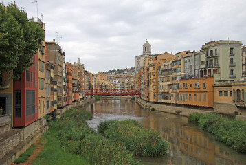 Fototapeta na wymiar GIRONA, SPAIN - AUGUST 30, 2012: View of the old town with colorful houses on the bank of the river Onyar
