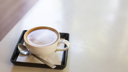 Hot art Latte Coffee in a cup and laptop on wooden table.