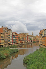 Fototapeta na wymiar GIRONA, SPAIN - AUGUST 30, 2012: View of the old town with colorful houses on the bank of the river Onyar