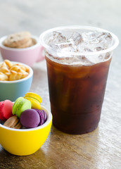 black ice coffee and dessert in cup on wooden background