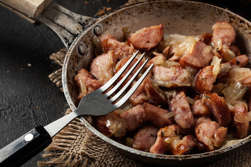 Pieces of sausage fried with onions