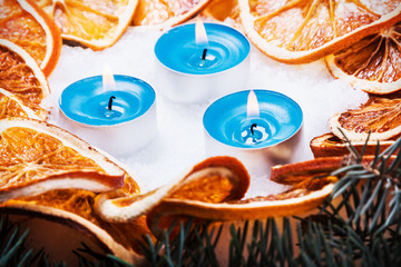 dried oranges and candles in the snow