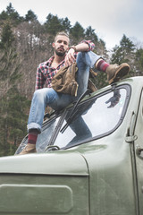 Young man on vintage truck with logs