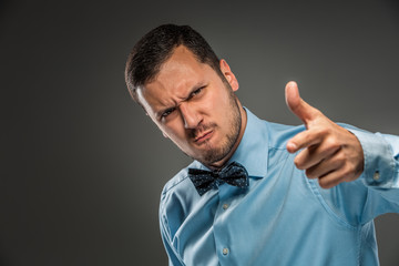 Portrait angry upset young man in blue shirt, butterfly tie 