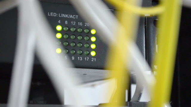 Network equipment green led lights and network yellow and grey cables. Shallow depth of field
