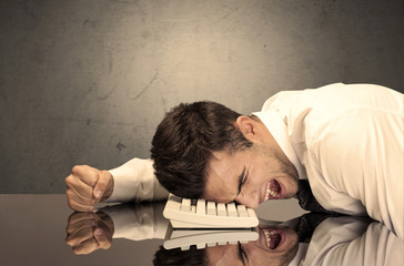 Obraz premium Frustrated businessman's head on keyboard