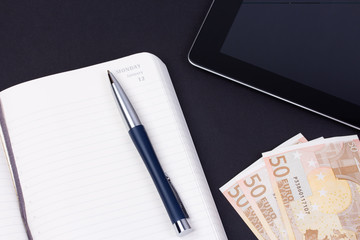 Open daily planner with luxury ball pen and tablet computer