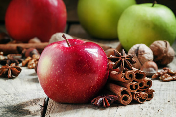 Fresh red and green apples, cinnamon sticks, ground cinnamon, an