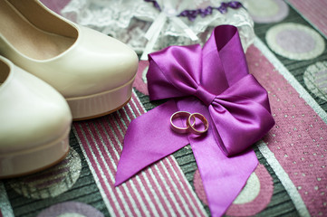 still life with wedding bride shoes and garter and gold rings