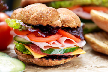 Grilled Sandwich with lettuce, slices of fresh tomatoes, cucumber, red onion, salami, ham and cheese.