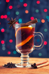 glass of mulled wine with spice on the bokeh background creates