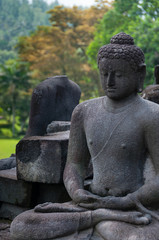 Fototapeta na wymiar Meditating sitting Buddha in stone at Borobudur