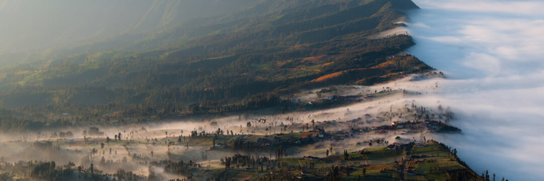 Fog and Mist Oozing Into the Field next to smoking volcano Bromo