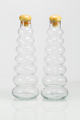 Modern clear bottles with reflection on white background