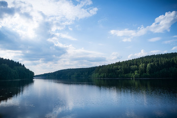 Fototapeta na wymiar Forest lake with blue sky