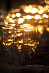 Champagne flautes prepared for a wedding reception with a ray of light