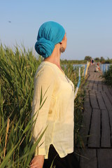 The girl in a blue turban and yellow blouse on the bridge