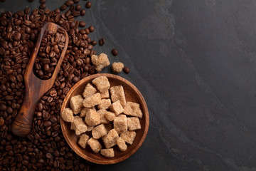 Coffee beans and brown sugar on stone table