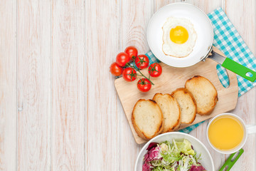 Healthy breakfast with fried egg, toasts and salad