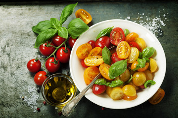 Fresh tomatoes with basil leaves in a bowl