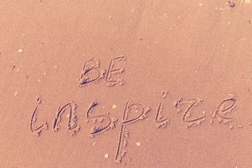 Be inspire written on the beach sand
