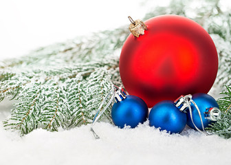 Beautiful blue and red Christmas balls on frosty fir tree. Christmas ornament.