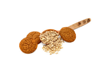wooden spoon with oatmeal and oatmeal cookies on a white backgro